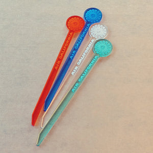 Acrylic engraved swizzle sticks in the style of Air California.